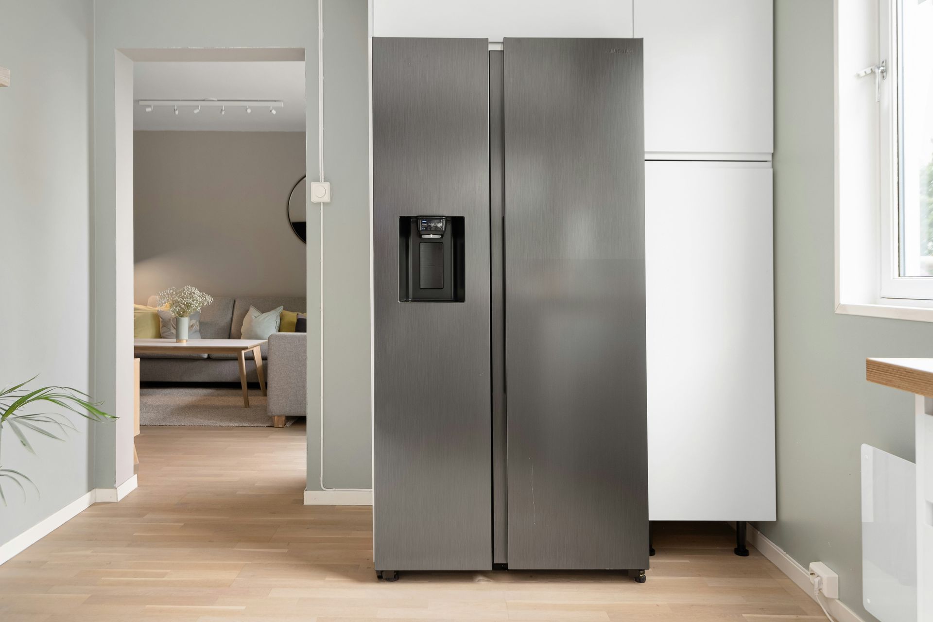 A refrigerator in a kitchen next to a window